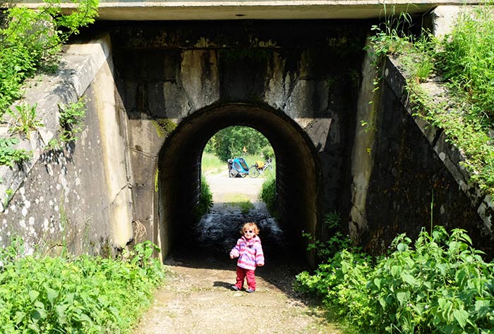 Erin devant le petit tunnel avant de la franchir avec les vélos et la carriole.