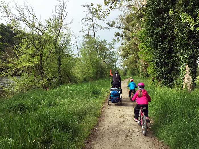 sur le chemin à vélo en famille avec la remorque