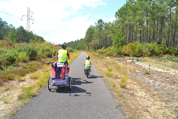 piste cyclable parent avec remorque et enfant