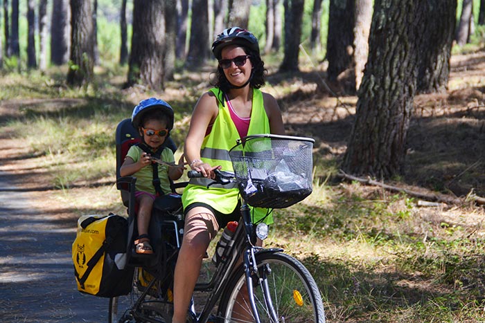 portrait maman et l'enfant sur le vélo dans le siège bébé sur la voie verte