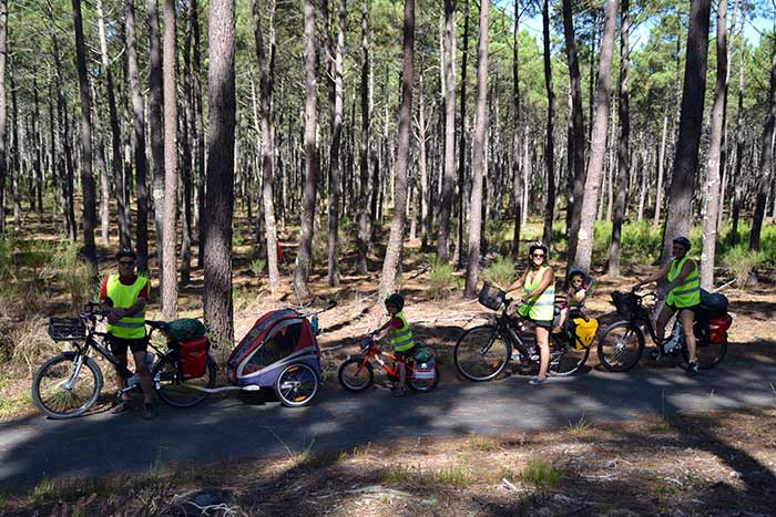 portrait de famille sur la voie verte à travers la forêt de pins