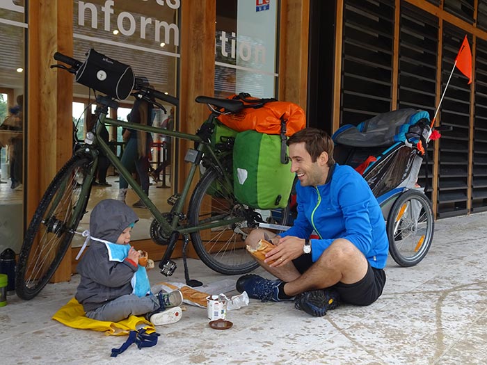 papa et son enfant avec la remorque vélo