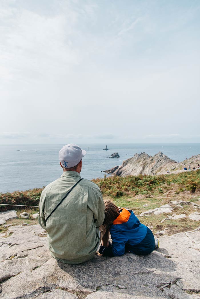 Papa et son fils contemplent le paysage à la Pointe du Raz en Bretagne