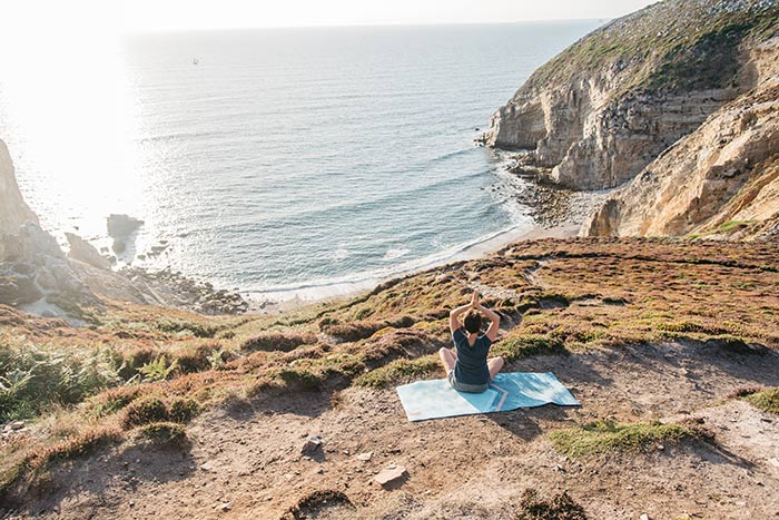 Femme en séance de yoga pour au Cap de la Chèvre dans le Finistère