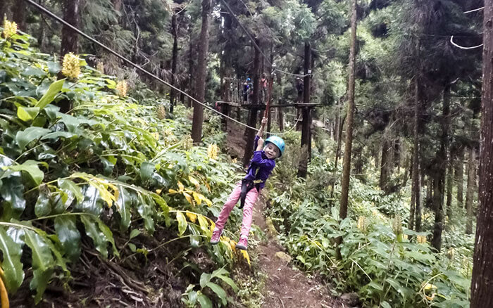 petite fille en tyrolienne dans un acrobranche de l'île de la Réunion