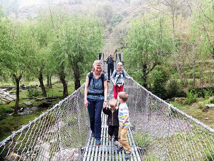 famille sur un pont suspendu le long d'un trek au Népal