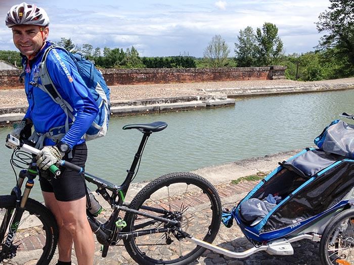 Photo de David, son vélo et sa remorque sur le Canal Latéral en bord de Garonne