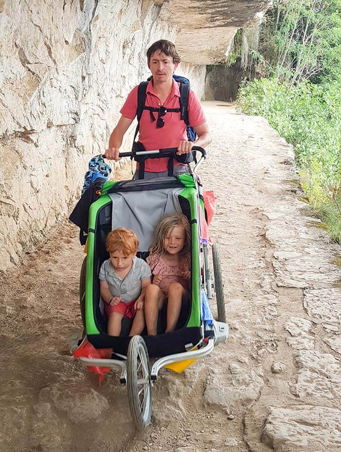 papa et ses enfants sur chemin de halage creusé dans la roche dans la vallée du lot