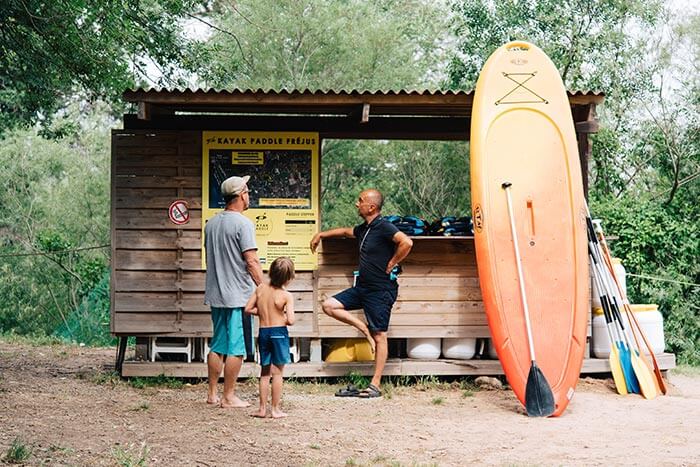 une famille de clients échange avec le chef de base nautique kayak paddle fréjus