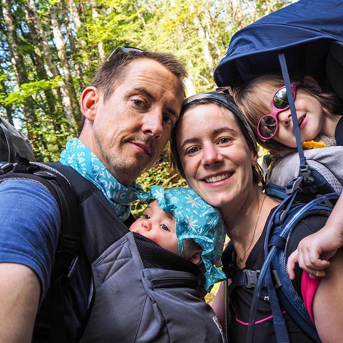 portrait de famille : papa, maman et leurs 2 petites filles dans la nature