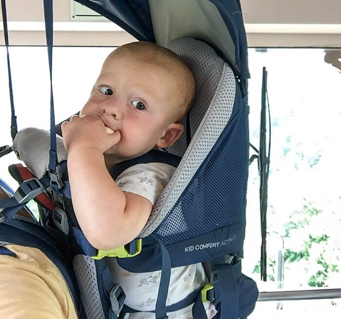 enfant qui mange installé dans le porte bébé de randonnée Deuter Kid Comfort Active 2019