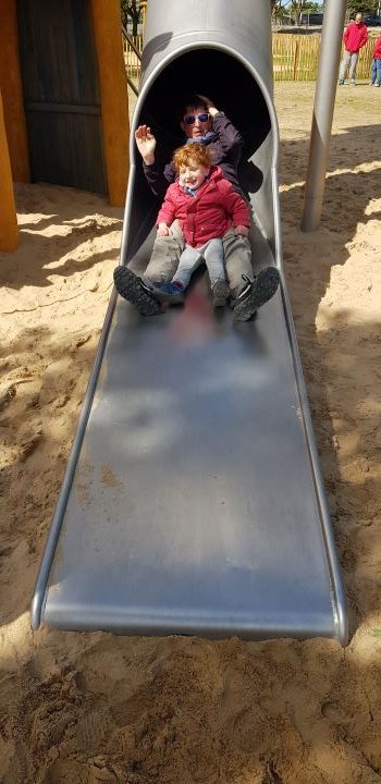 Fils et père glissent sur un toboggan