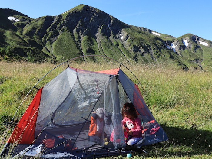 enfants dans une tente en bivouac dans les alpes