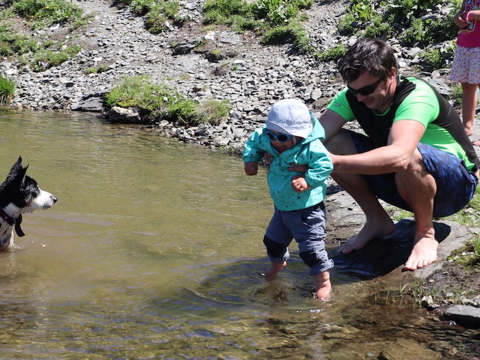 enfant et parents dans une rivière en randonnée