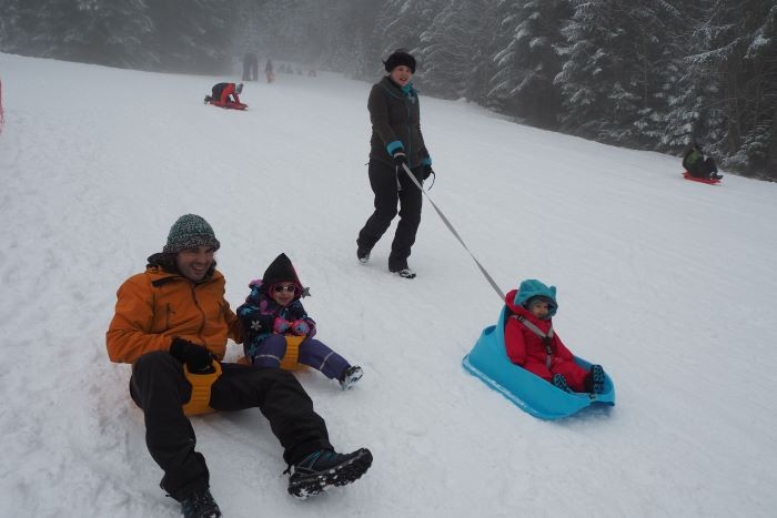 famille faisant de la luge à la ruche à giter la ruchère