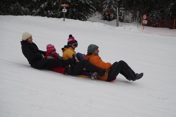 famille faisant de la luge à la ruche à giter la ruchère