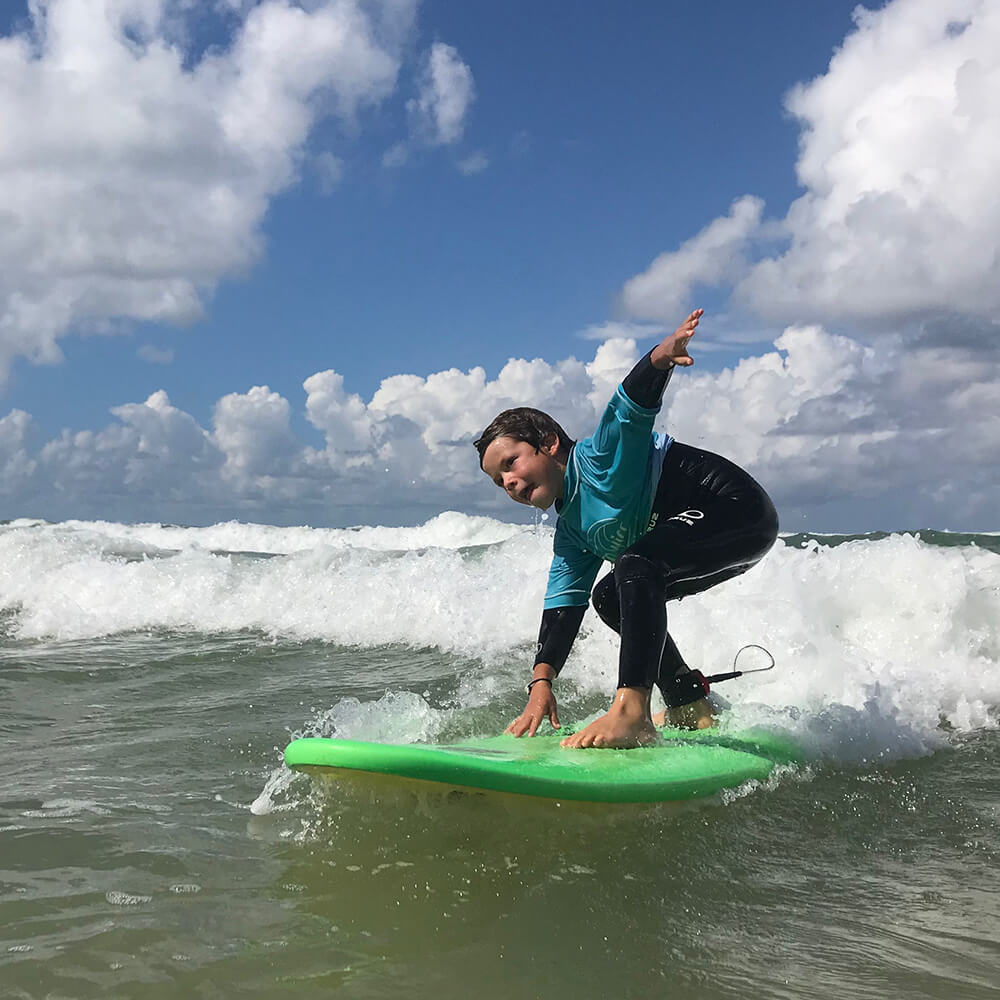 Enfant pratiquant le surf à l'océan.