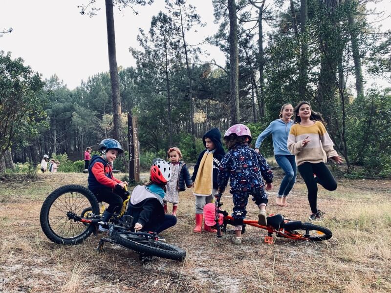 enfants qui courent dans une forêt de pins