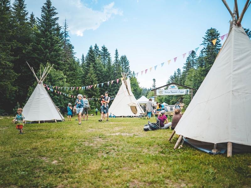 des festivaliers entre les tipis au camp de base